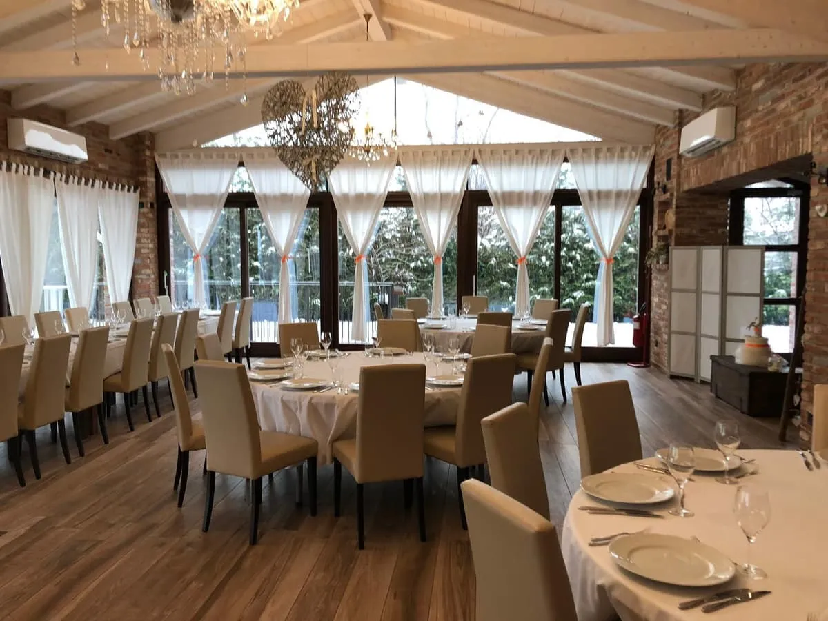 Sala del ristorante con travi a vista e tavoli apparecchiati